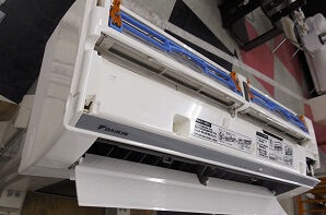 スタッフが清掃後のルームエアコンを斜め上から撮影